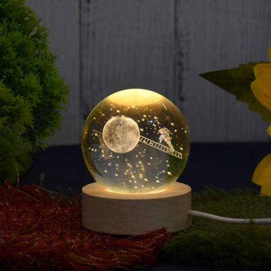 Decorative night light with moon and ladder design on a marble base, surrounded by plants.
