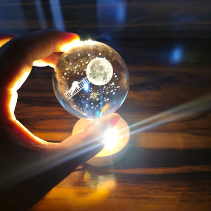3D Crystal Ball Astronaut Night Lamp off in hand with light behind it