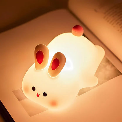 Big Face Rabbit Silicone Night Lamp on a book
